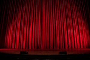 Sipario rosso di un teatro (foto Rob Laughter, Unsplash)